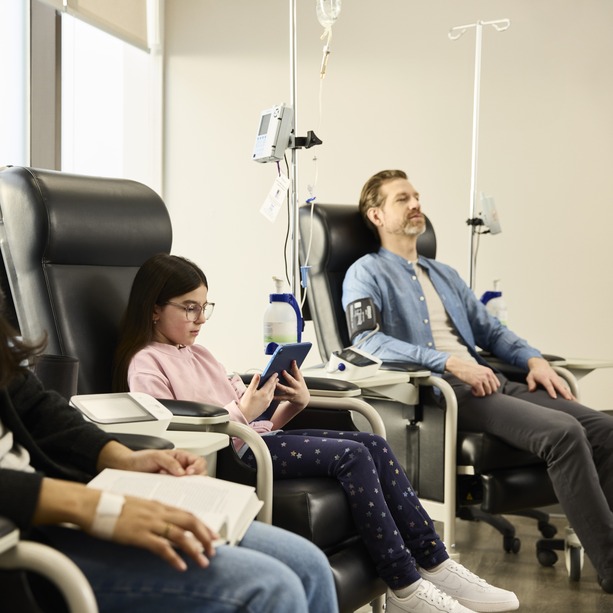 Three patients sitting side by side in an INVIVA clinic receiving treatment.